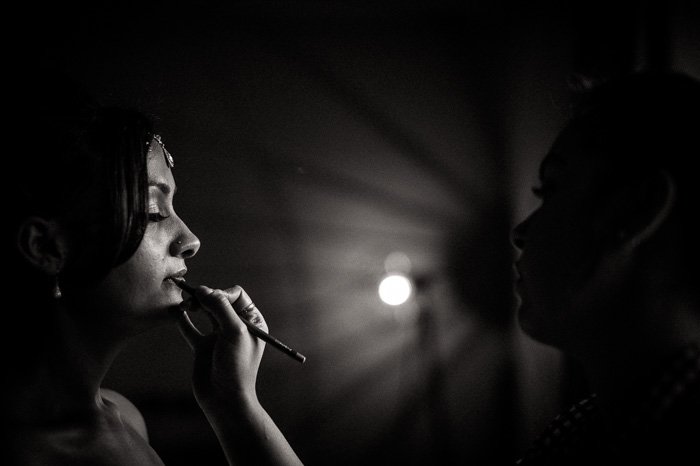 a shallow focus black and white portrait of woman applying makeup shot with a prime lens