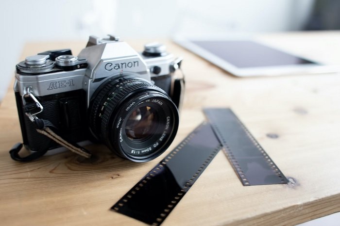 Canon AE-1 on a table with some film negatives