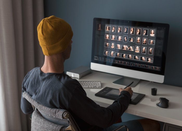 a man in a hat working at home on his compiuter