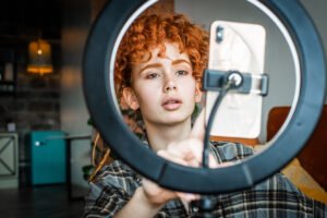 Female blogger with ring light and smartphone for best lighting for zoom calls