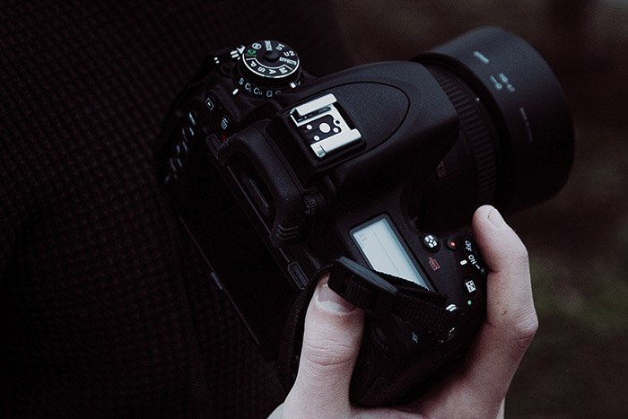 a photographer adjusting burst mode settings on a DSLR camera