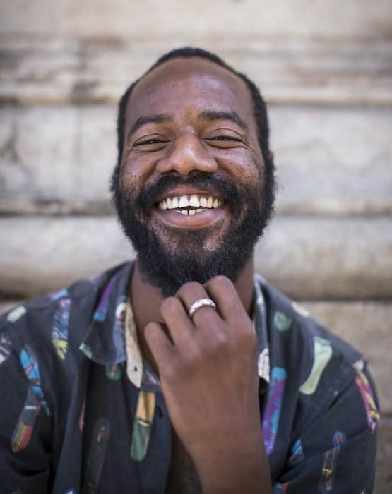 A man with a beard in front of a wall taken with a camera for portraits