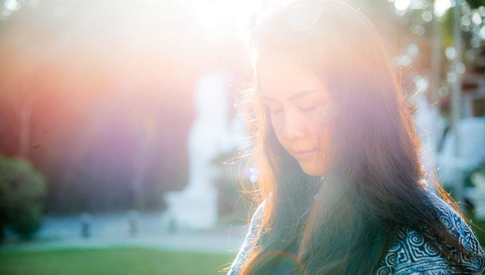 Outdoor portarit of a female model with lens flare from incident lighting 