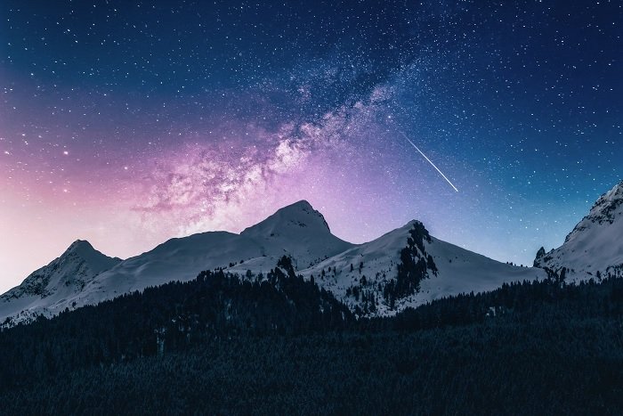 Snowy mountains against a starry night sky