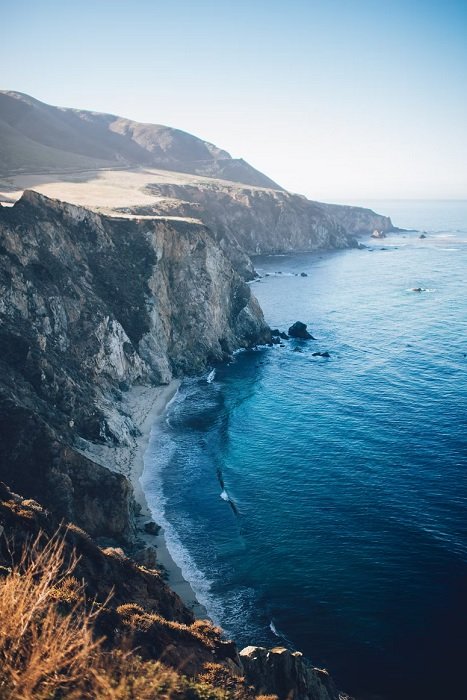 Photo from cliff edge looking down on coastal cliffs