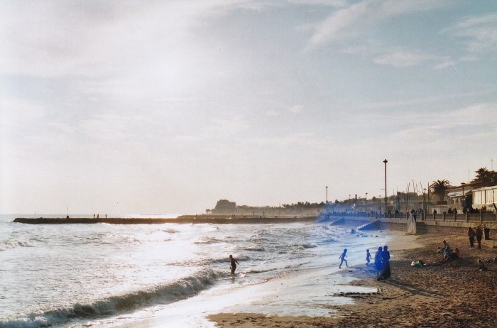 Beach scene during the golden hour with children playing in the surf