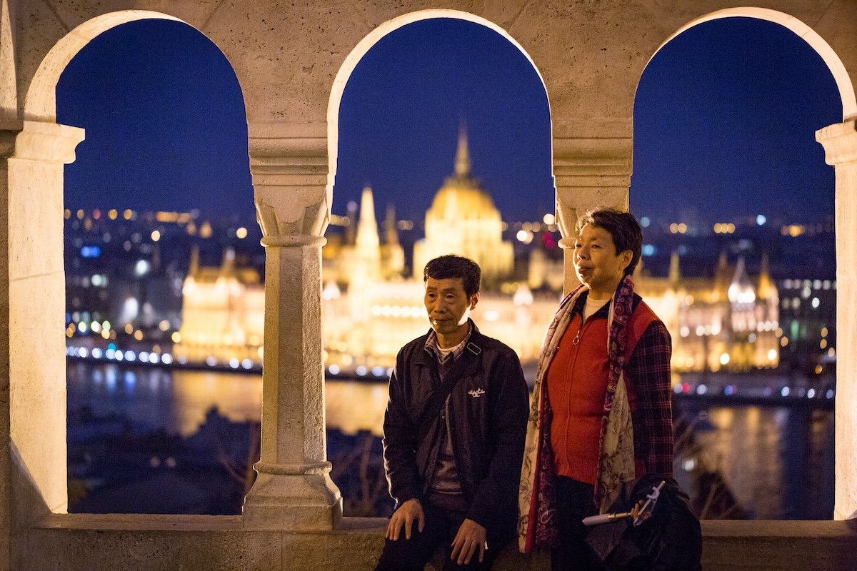 photograph of couple sitting with a view behind them