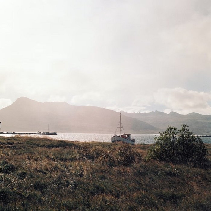 Landscape of coast with boat and mountains