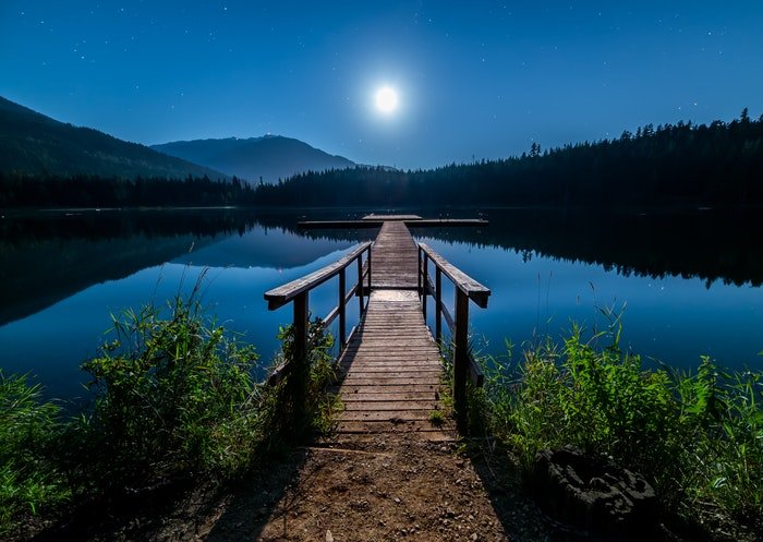 A pier at a lake at night