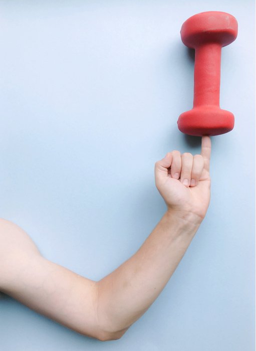 An image of a perspective trick with an arm holding a weight on the pinky finger. 