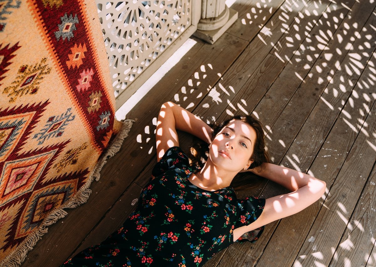 A woman lying down with lighting patterns falling across her