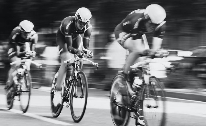 Three professional cyclists racing in line