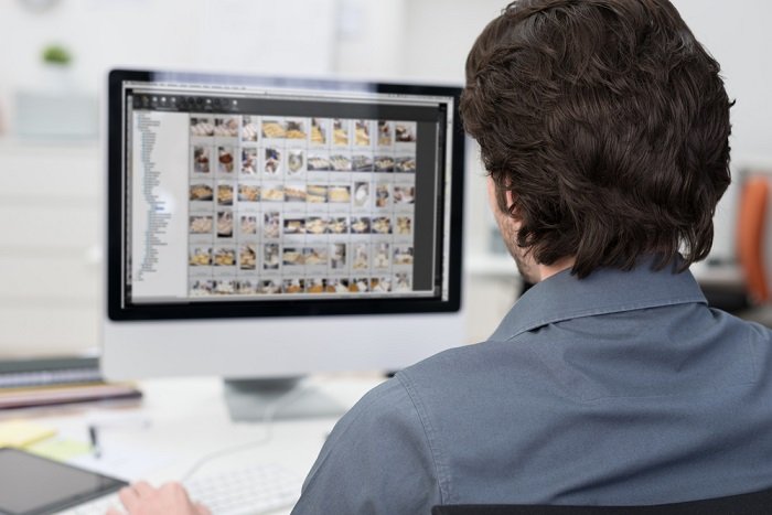 The back of a man's head who's working in Lightroom