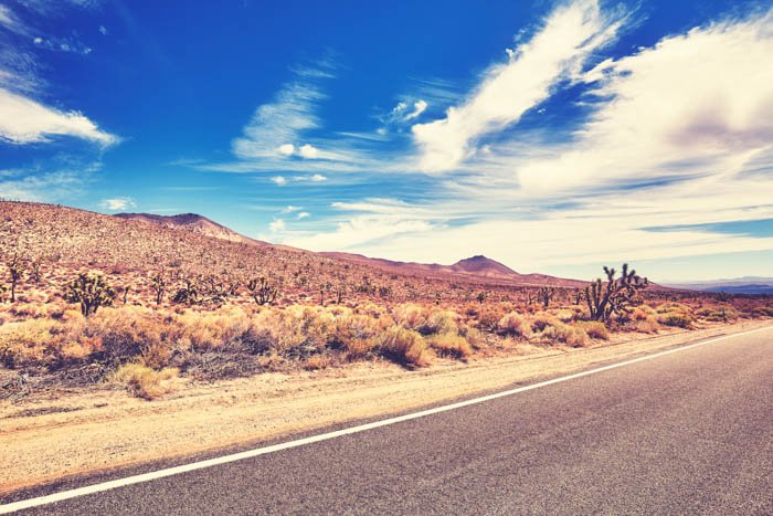 A saturated image of a road and the desert behind it