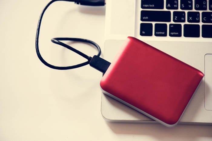 An external hard drive placed on a laptop.