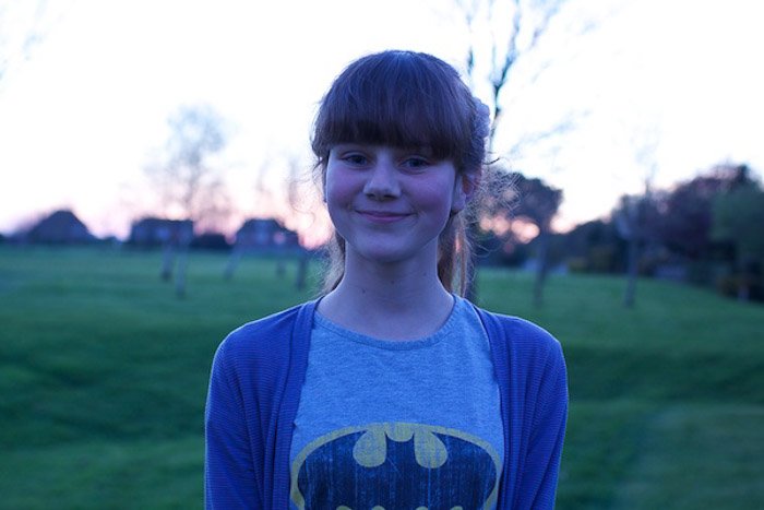 A portrait of a young girl posing outdoors,